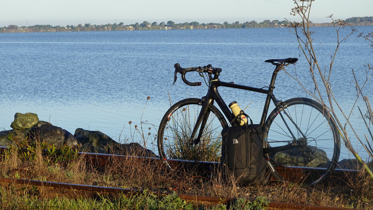 INUK CRUISER backpack beside a bicycle by the water